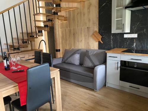 a kitchen and living room with a couch and a table at Leśny Zakątek in Poronin