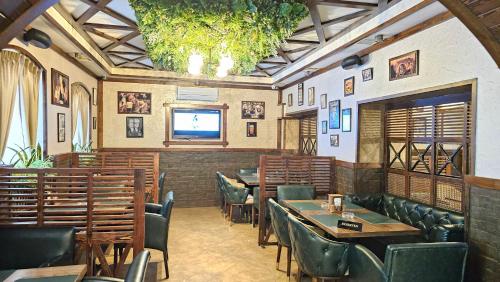 a restaurant with tables and chairs and a flat screen tv at Hotel & Bistro in Baku