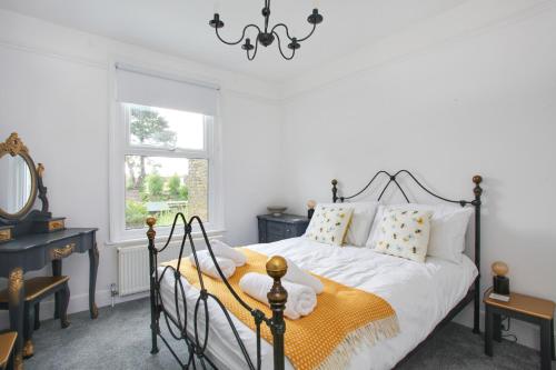 una camera con un letto bianco e nero e una finestra di Sea Salt Cottage - Mins to beach & shops Dog Friendly a Deal