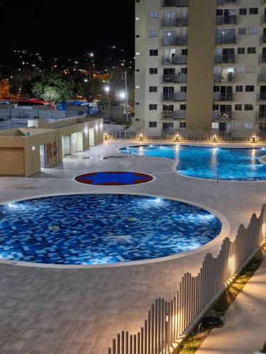 uma grande piscina com água azul em frente a um edifício em Acogedor apartamento en Santa Marta em Santa Marta