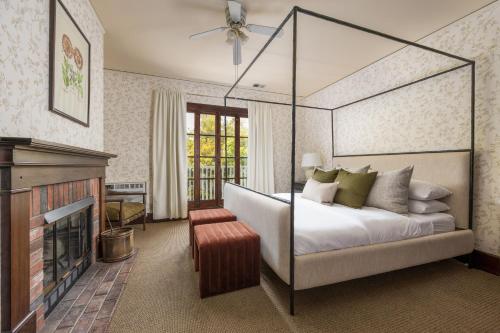 a bedroom with a canopy bed and a fireplace at De La Vina Inn in Santa Barbara