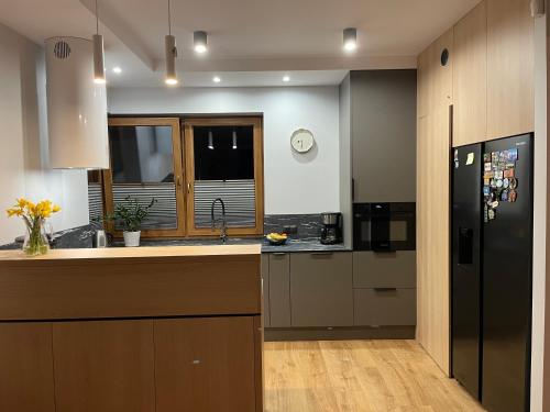 a kitchen with a black refrigerator and a sink at MARS HOME in Kołobrzeg