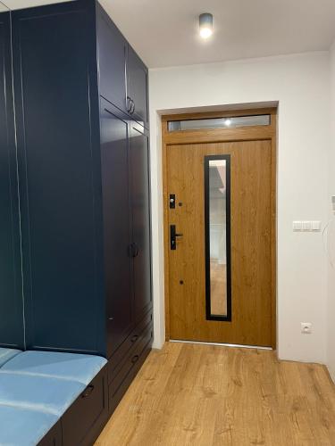 a kitchen with blue cabinets and a wooden door at MARS HOME in Kołobrzeg