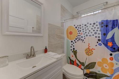 a bathroom with a toilet and a shower curtain at The Douglas Apartment in Columbia