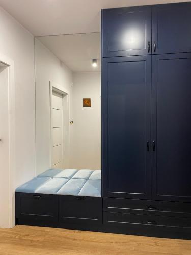 a large black cabinet in a room with a bed at MARS HOME in Kołobrzeg