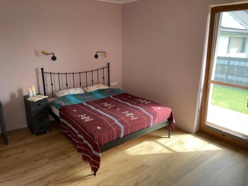 a bedroom with a bed and a large window at MARS HOME in Kołobrzeg