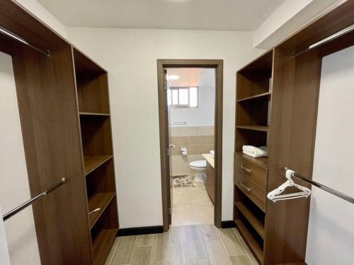 a bathroom with a toilet and a wooden closet at Lovely 3-bedroom rental unit with free parking in Guatemala