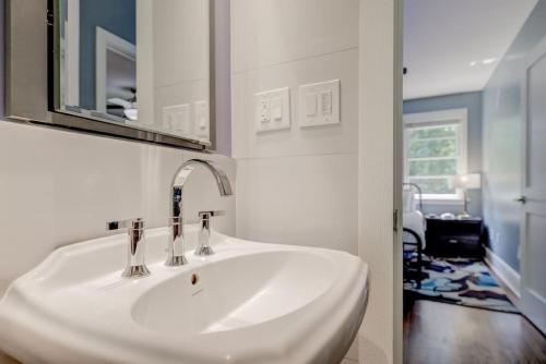 La salle de bains est pourvue d'un lavabo blanc et d'un miroir. dans l'établissement Relaxing Cozy Apt. in Cola, à Columbia