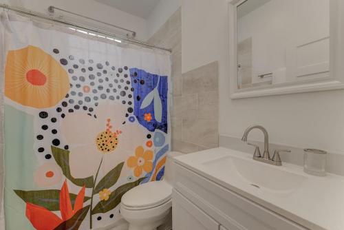 a bathroom with a toilet and a shower curtain at The Bruce Apartment in Columbia