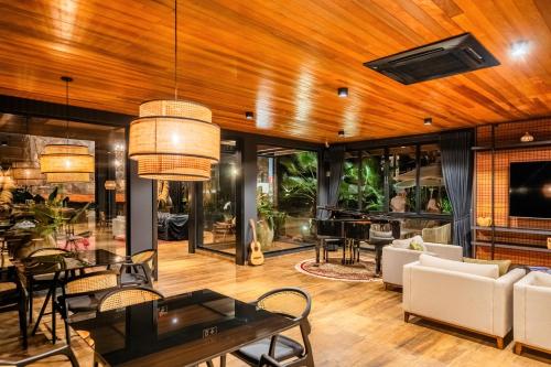 un soggiorno con tavolo, sedie e pianoforte di LAS HOTEL BOUTIQUE a Foz do Iguaçu