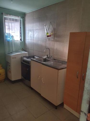 uma cozinha com um lavatório e um fogão em Acogedora Habitación San Pedro de Atacama em Toconao