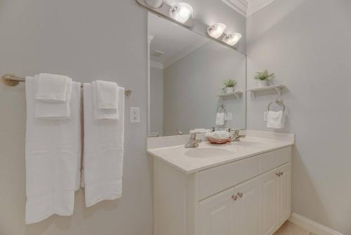 Baño blanco con lavabo y espejo en Town Center Executive Condo, en Columbia