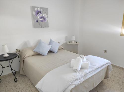 sypialnia z białym łóżkiem i ręcznikami na nim w obiekcie Valdelagrana Marinero w mieście El Puerto de Santa María