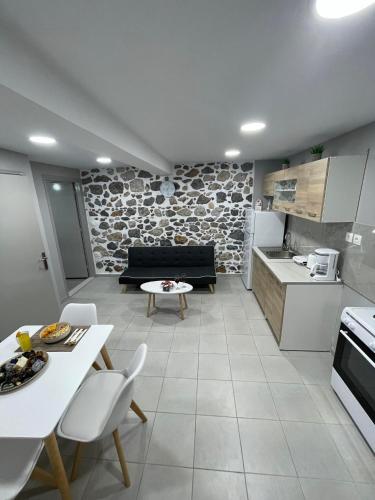 Meraki house of kalymnos Apartments في كاليمنوس: مطبخ وغرفة معيشة مع أريكة وطاولة