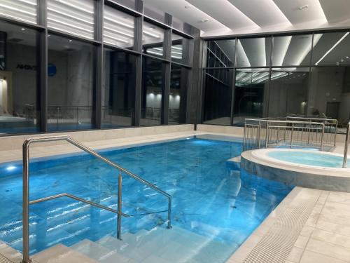 a large pool with blue water in a building at Apartament Holiday Mini Gold in Rewal