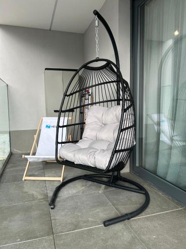 a black bird cage with white pillows in it at Apartament Holiday Mini Gold in Rewal