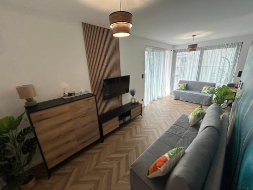 a living room with a couch and a flat screen tv at Apartament Holiday Mini Gold in Rewal