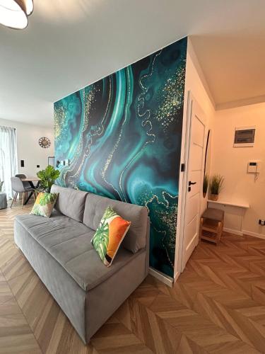 a living room with a couch in front of a wall at Apartament Holiday Mini Gold in Rewal