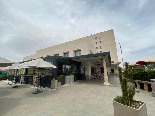a building with umbrellas in front of it at Hotel Sercotel Cuatro Postes in Avila