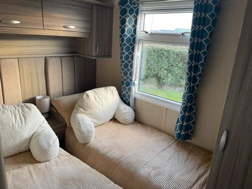 a small room with a bed and a window at Luxury Romantic 2 Bedroom Caravan Trecco Bay in Newton