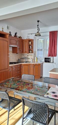 a kitchen with a glass table and some chairs at Dom nad Wisłą in Czernichów