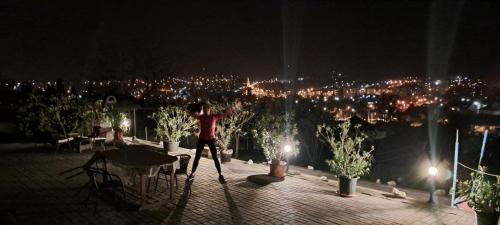 a woman is standing on a balcony at night at Szent Iván Apartman in Eger
