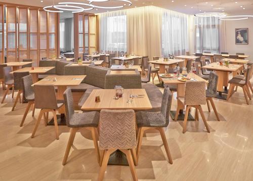 - un restaurant avec des tables et des chaises dans une salle dans l'établissement Hotel Barbaric, à Međugorje