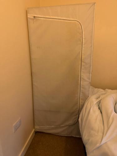 a bed with a white pillow in a room at Bedsit room in Thamesmead
