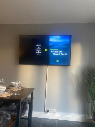a flat screen tv hanging on a wall at THE ENCHANTED COTTAGE in Rolleston