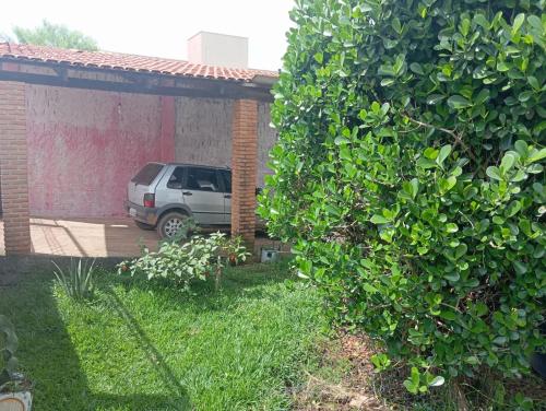 een auto geparkeerd in een tuin naast een gebouw bij Casa Central in Alto Paraíso de Goiás