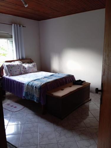 een slaapkamer met een bed, een stoel en een raam bij Casa Central in Alto Paraíso de Goiás