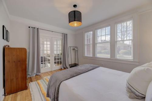 a bedroom with a large white bed and windows at Spacious Industrial Modern Apt in Columbia