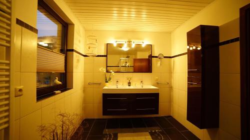 a bathroom with a sink and a mirror at 4-Personen-Ferienwohnung-im-Wald-mit-Kamin-84-Qudratmeter in Bad Harzburg