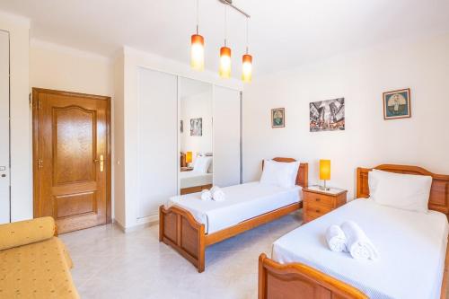 a bedroom with two beds and a couch at Villa Glória in Praia do Carvoeiro