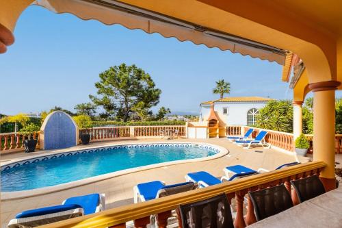a balcony with a swimming pool and chairs at Villa Glória in Praia do Carvoeiro