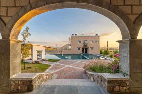 een boog die leidt naar een huis met een zwembad bij Rancho Santa Sofía in El Santuario