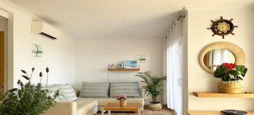 a living room with a couch and a clock on the wall at Cosy home / vue mer / vue montagne / 4 voyageurs in Muntanya la Sella