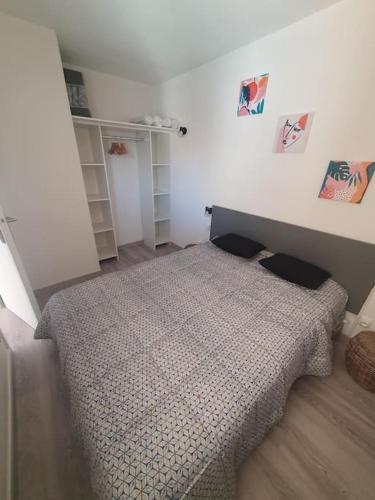 une chambre avec un lit dans une pièce dans l'établissement LES TERRASSES DE LA BARONNIE Appartement climatisé avec 1 chambre et piscine ouverte du 28 Mai 2025 au 28 Septembre 2025, au Grau-du-Roi