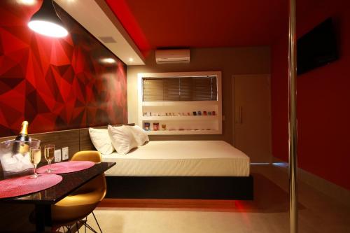 a small bedroom with a bed and a table at Oasis Motel in Piracicaba