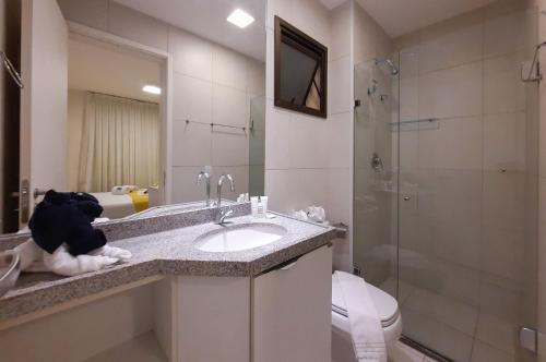 een badkamer met een wastafel, een toilet en een douche bij Vg Sun Cumbuco Vista Mar Pertinho Praia in Caucaia