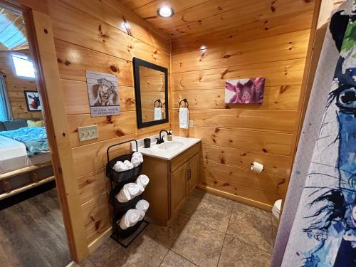a bathroom with a sink in a log cabin at Prime Location & Loaded For Family Fun in Pigeon Forge