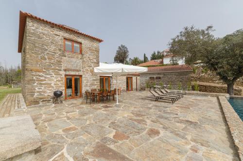 een stenen patio met tafels en stoelen voor een gebouw bij Tapada De Sao Domingos in Gondomar