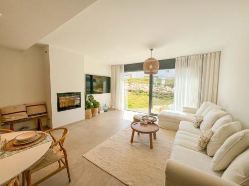 a living room with a white couch and a table at Tarifa Cozy House - La Tramontana in Tarifa