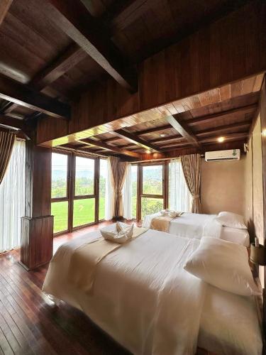 a large bedroom with two beds and windows at Mai Chau Onsen Retreat in Mai Chau
