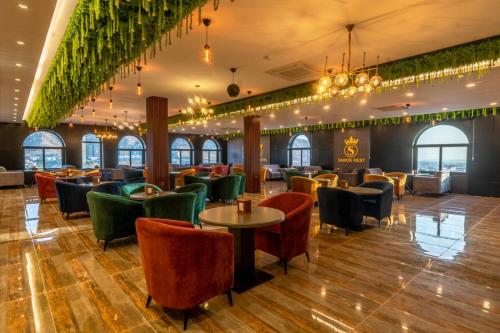 Sarok Hotel في دهوك: مطعم فيه كراسي وطاولات في الغرفة