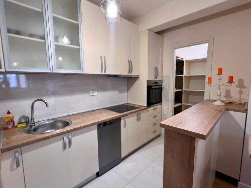 a kitchen with white cabinets and a sink at White Homes - Central Point in Podgorica