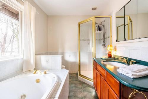 La salle de bains blanche est pourvue d'une baignoire et d'un lavabo. dans l'établissement Boathouse on the Hudson, à Saugerties