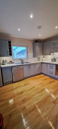 a large kitchen with wooden floors and white cabinets at St Albans Apartment in St. Albans