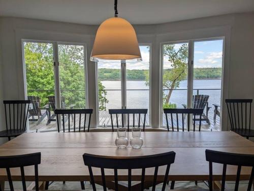 a dining room with a large wooden table with chairs at Hudson River Cliff House in Saugerties
