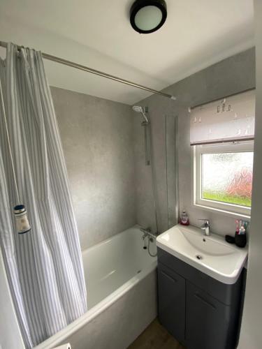 a bathroom with a tub and a sink and a shower at 95 Sundowner, Hemsby, Norfolk in Hemsby